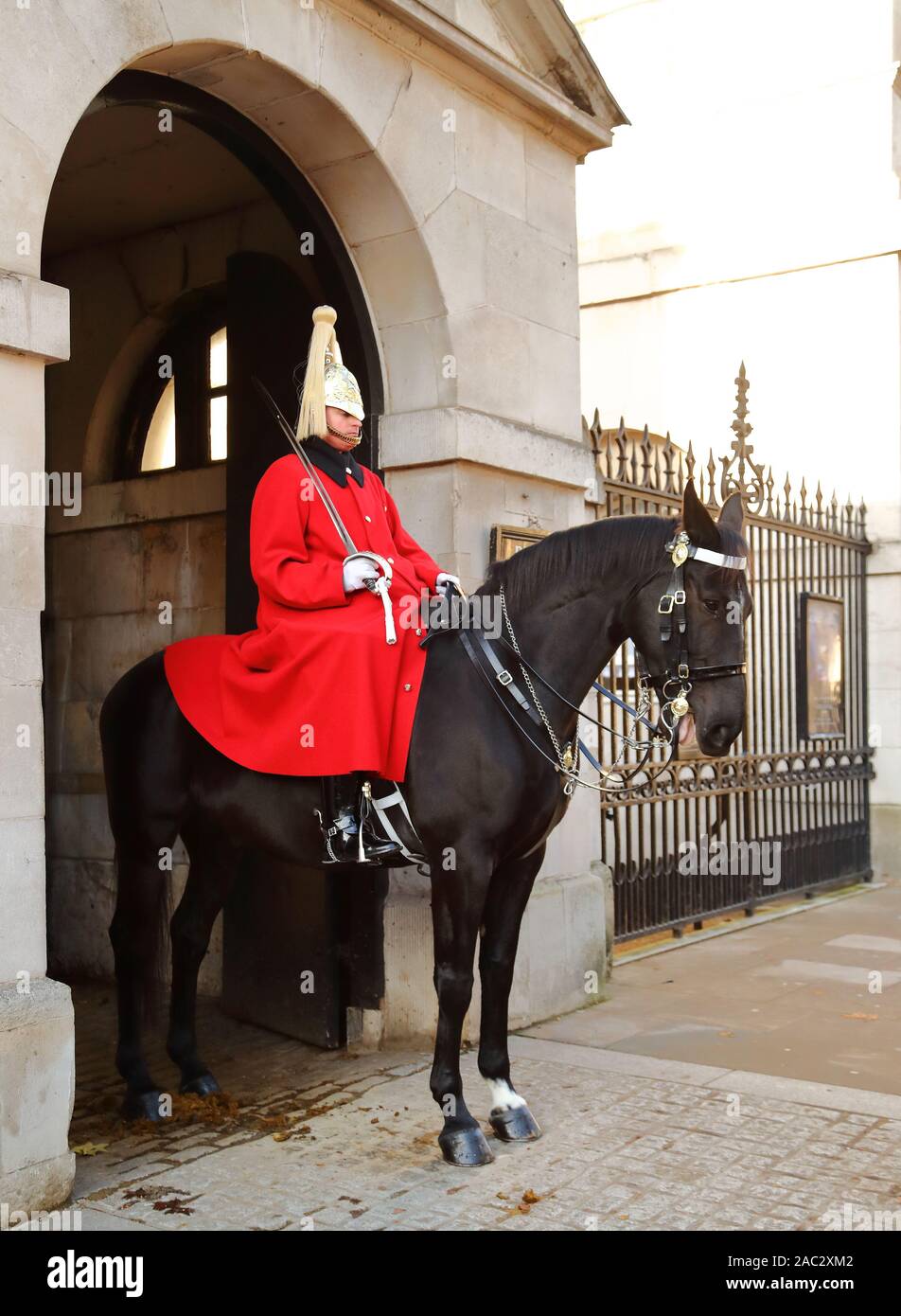 Cavalleria domestici nel loro tradizionale rosso lungo cappotti uniforme a Whitehall, London, Regno Unito Foto Stock