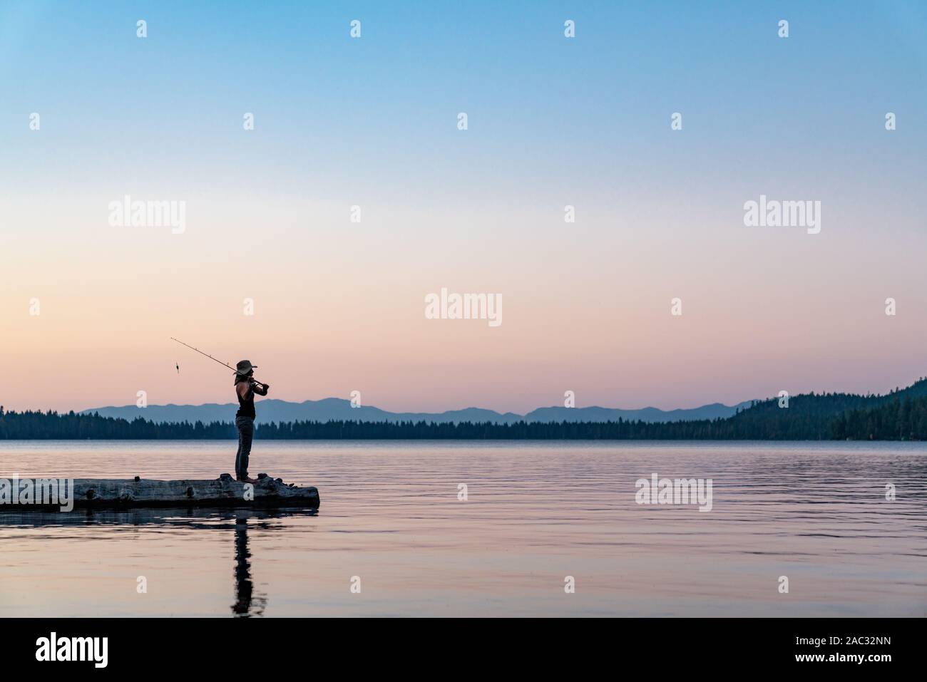 Una donna di pesca durante il tramonto in Lake Tahoe, Nevada Foto Stock Una donna di pesca durante il tramonto in Lake Tahoe, Nevada Foto Stock