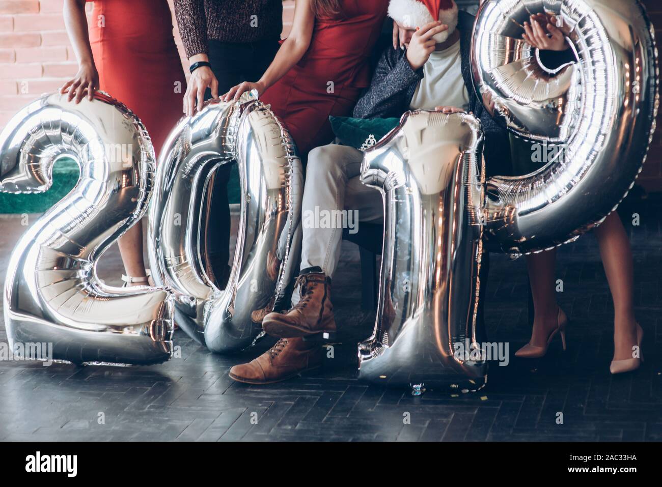 Sul pavimento. Il gruppo di amici con i numeri gonfiabile in mani per celebrare il nuovo anno 2019 Foto Stock