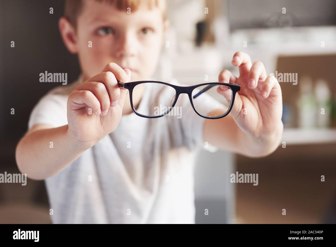 Little Boy mantiene i suoi nuovi occhiali nell'ufficio del medico Foto Stock