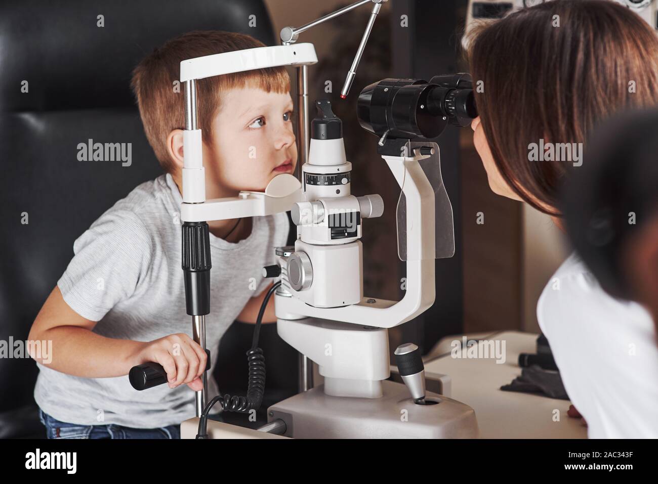 Si prega di non spostare i vostri occhi. Little Boy sono la prova per i suoi occhi con una speciale apparecchiatura ottica dal medico donna Foto Stock