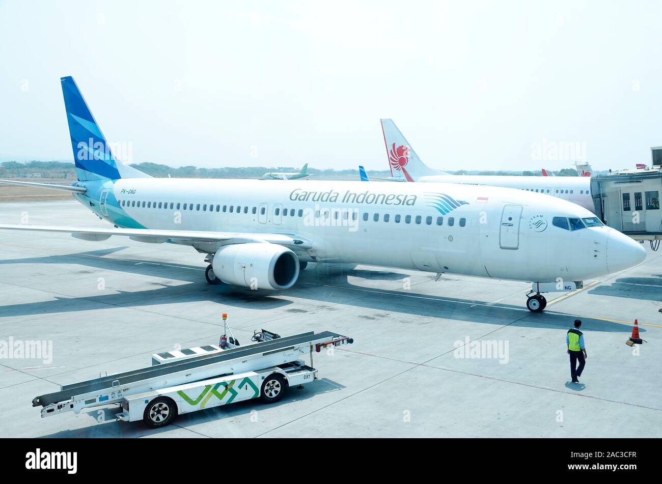 Un Boeing 737 serie,Garuda Indonesia Airlines presso la pista di rullaggio, con lo sfondo Lion air aeromobili, al Aji Pangeran Tumenggung Pranoto Airport Foto Stock