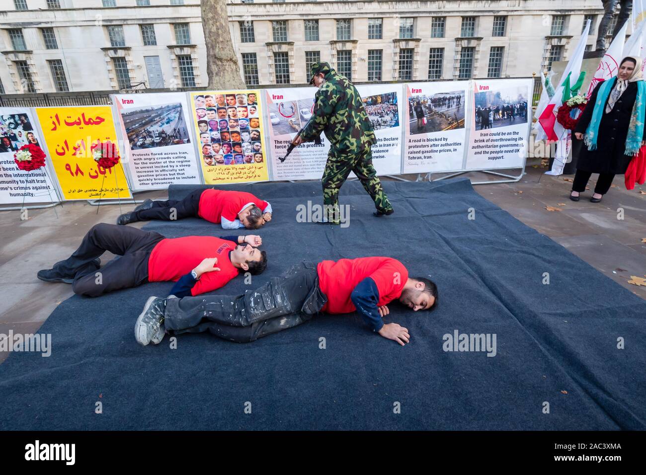 Londra, Regno Unito. 30 Novembre, 2019. Attori ri-emanare le riprese di manifestanti da iraniani le forze di sicurezza in un rally da Anglo-Iranian europee nel Regno Unito e sostenitori dei mujaheddin del popolo dell'Iran del consiglio nazionale della resistenza iraniana a Downing St a sostegno delle proteste in Iran contro il regime clericale. Oltre 450 manifestanti sono stati uccisi nella repressione brutale dell'Iran proteste da parte delle forze di sicurezza, con 4000 feriti e migliaia arrestati. Credito: Peter Marshall / Alamy Live News Foto Stock