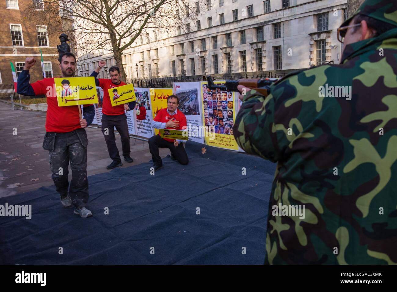 Londra, Regno Unito. 30 Novembre, 2019. Attori ri-emanare le riprese di manifestanti da iraniani le forze di sicurezza in un rally da Anglo-Iranian europee nel Regno Unito e sostenitori dei mujaheddin del popolo dell'Iran del consiglio nazionale della resistenza iraniana a Downing St a sostegno delle proteste in Iran contro il regime clericale. Oltre 450 manifestanti sono stati uccisi nella repressione brutale dell'Iran proteste da parte delle forze di sicurezza, con 4000 feriti e migliaia arrestati. Credito: Peter Marshall / Alamy Live News Foto Stock