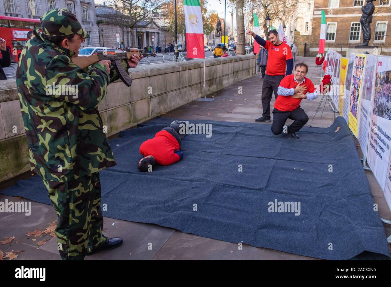 Londra, Regno Unito. 30 Novembre, 2019. Attori ri-emanare le riprese di manifestanti da iraniani le forze di sicurezza in un rally da Anglo-Iranian europee nel Regno Unito e sostenitori dei mujaheddin del popolo dell'Iran del consiglio nazionale della resistenza iraniana a Downing St a sostegno delle proteste in Iran contro il regime clericale. Oltre 450 manifestanti sono stati uccisi nella repressione brutale dell'Iran proteste da parte delle forze di sicurezza, con 4000 feriti e migliaia arrestati. Credito: Peter Marshall / Alamy Live News Foto Stock