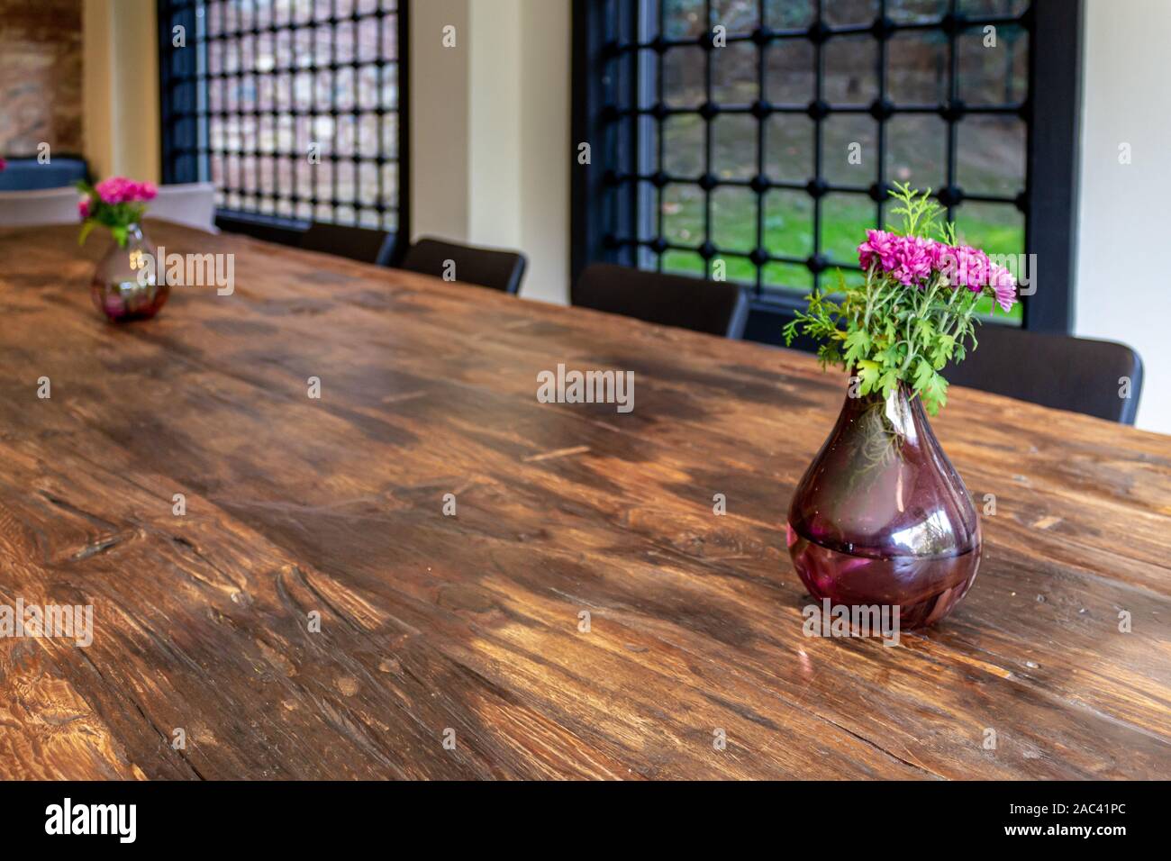 Vaso e bouquet di fiori in legno marrone tabella. Decorazione Home design. Ferro da stiro bloccate home finestra di vetro in background Foto Stock