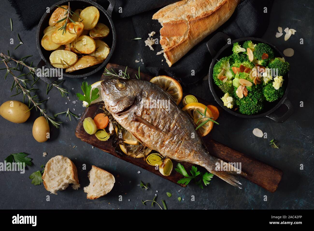 Fresco Forno orata al forno con erbe e limone, servito con patate e broccoli imburrato con la pasta di mandorle Foto Stock
