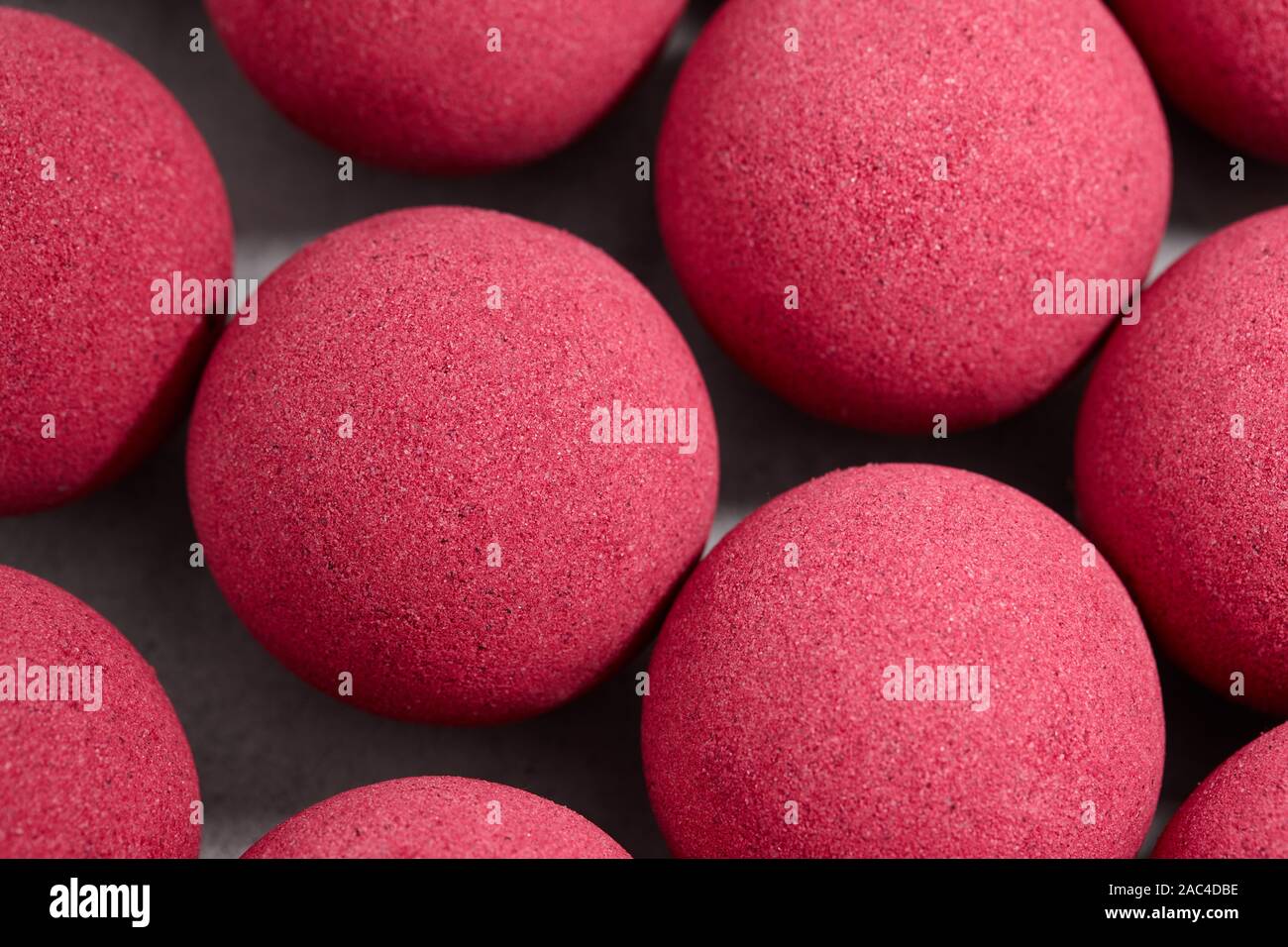 Bagno rosa bombe sul piano portapaziente grigio, vista ravvicinata Foto Stock