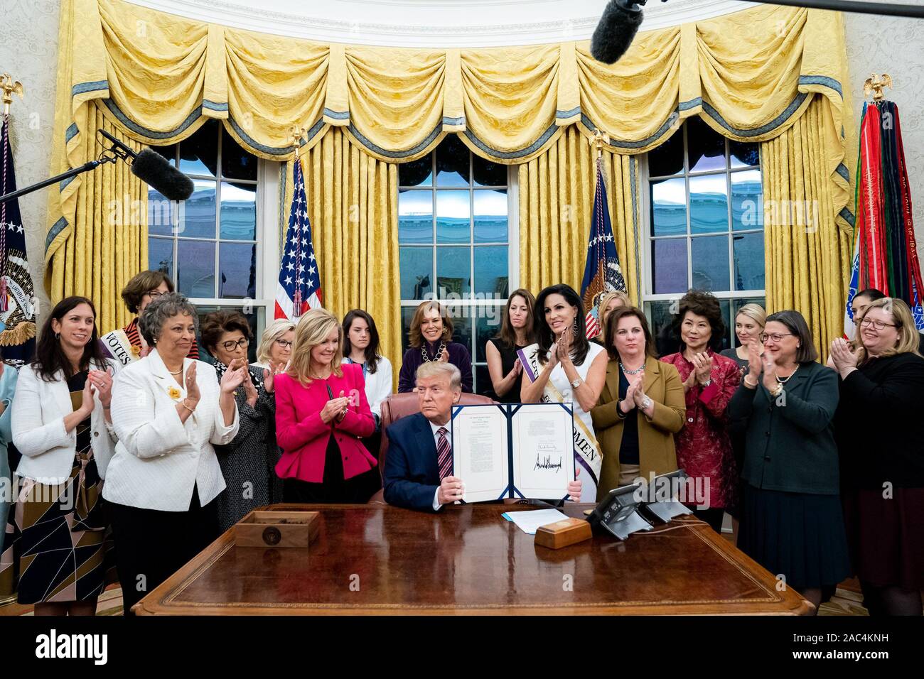 Presidente Trump è applaudita come egli mostra la sua firma dopo la firma H.R. 2423: il suffragio femminile Centennial una moneta commemorativa atto lunedì, nov. 25, 2019, nell'Ufficio Ovale della Casa Bianca. Foto Stock