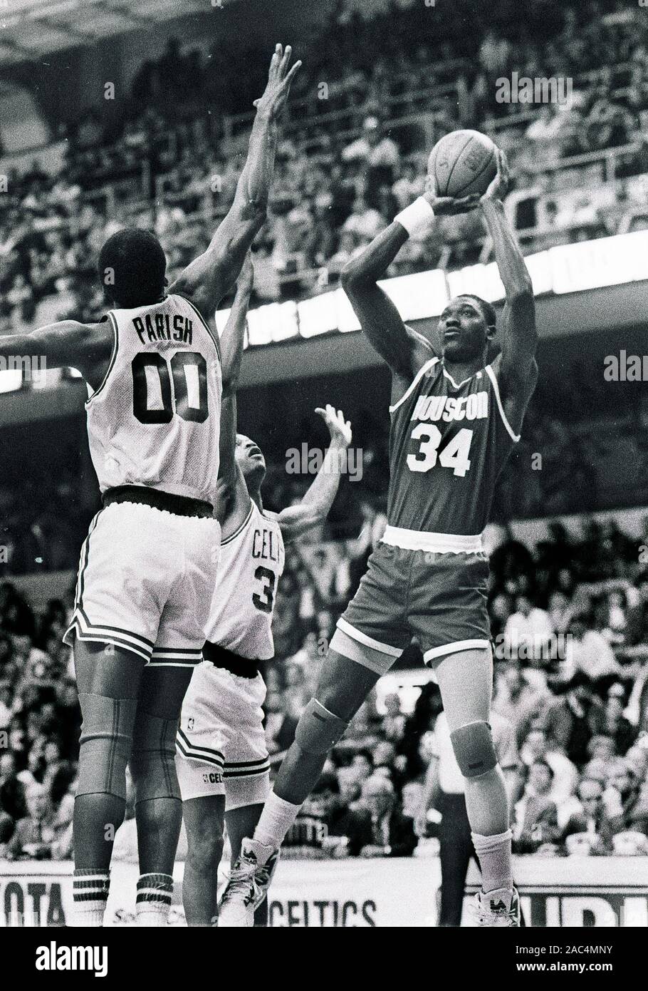 Houston Rockets Hakeem Olajuwon germogli su Boston Celtics #00 Robert Parrocchia e #35 Reggie Lewis durante il gioco del basket azione a Boston Garden in Boston ma USA 1988foto di bill belknap Foto Stock