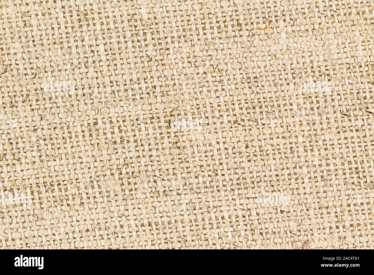 Close up sullo sfondo di un tessuto grossolanamente i filetti di iuta di tan tessuto di tela. AKA Hessian panno. Foto Stock