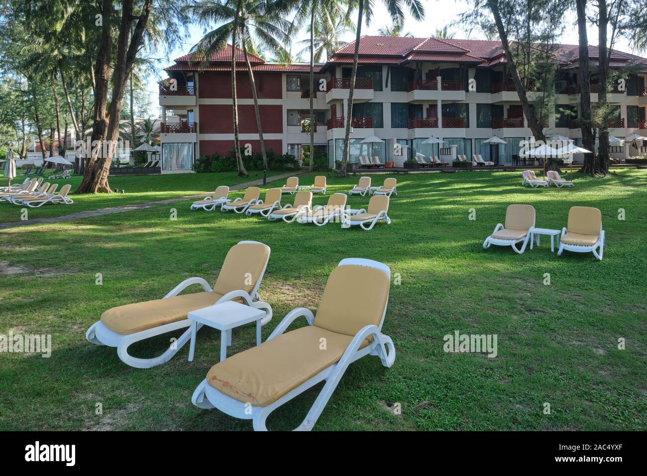 In un inizio di mattina, vuoto lettini per prendere il sole nel parco di Dusit Laguna Hotel a Bang Tao Beach, Phuket, Thailandia, attendono gli occupanti Foto Stock