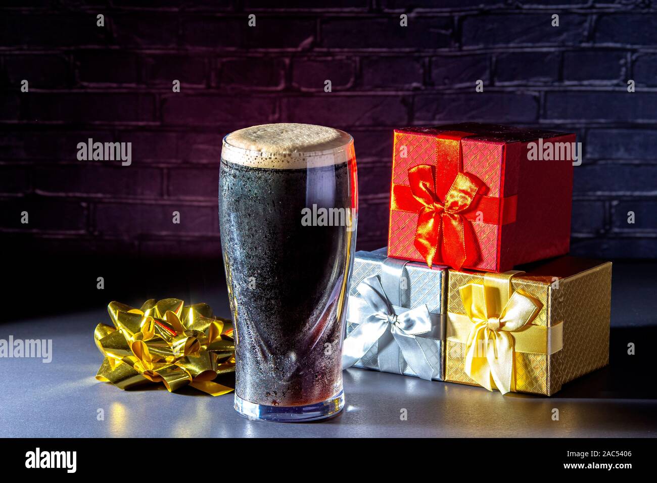 Un buio secco irlandese Birra stout un vetro con confezioni regalo Foto Stock