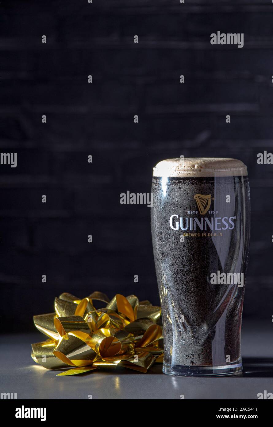 Calgary AB, Canada. Novembre 26, 2019. Un buio Irish dry stout birra di vetro con un nastro in regalo Foto Stock