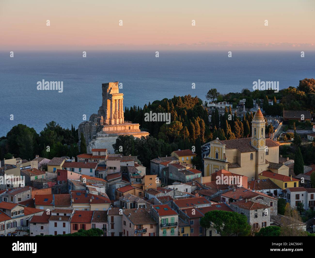 Tramonta il sole illuminando selettivamente un monumento romano di 2000 anni che si affaccia sul Mar Mediterraneo. La Turbie, Costa Azzurra, Alpi Marittime, Francia. Foto Stock