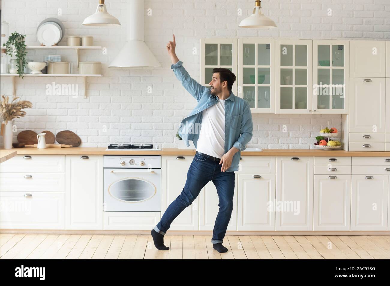 Spensierato divertente giovane divertirsi ballare da soli in cucina Foto Stock