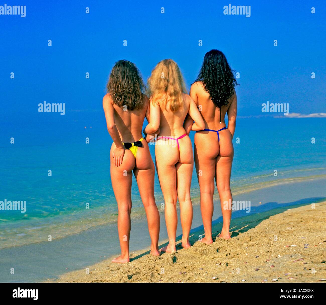 Drei Maedchen im Tanga am Strand von San Pietroburgo, Russland, Rückenansicht, Foto Stock