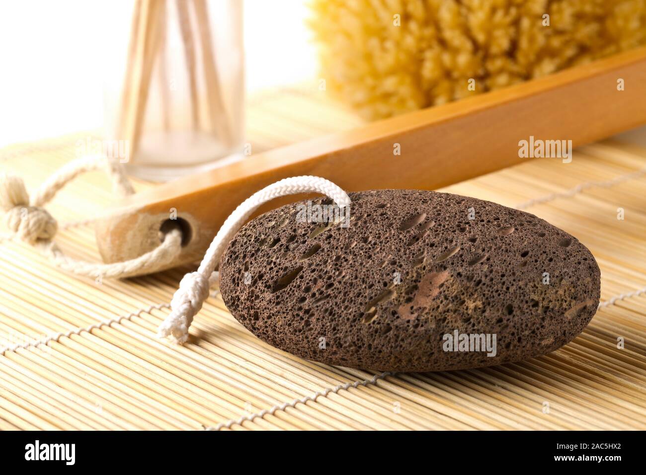 Lava nera pietra pomice con natural spa o bagno utensili usati per la pelatura o pelle callused distacco sul tappetino di bambù di sfondo - Il fuoco selettivo Foto Stock