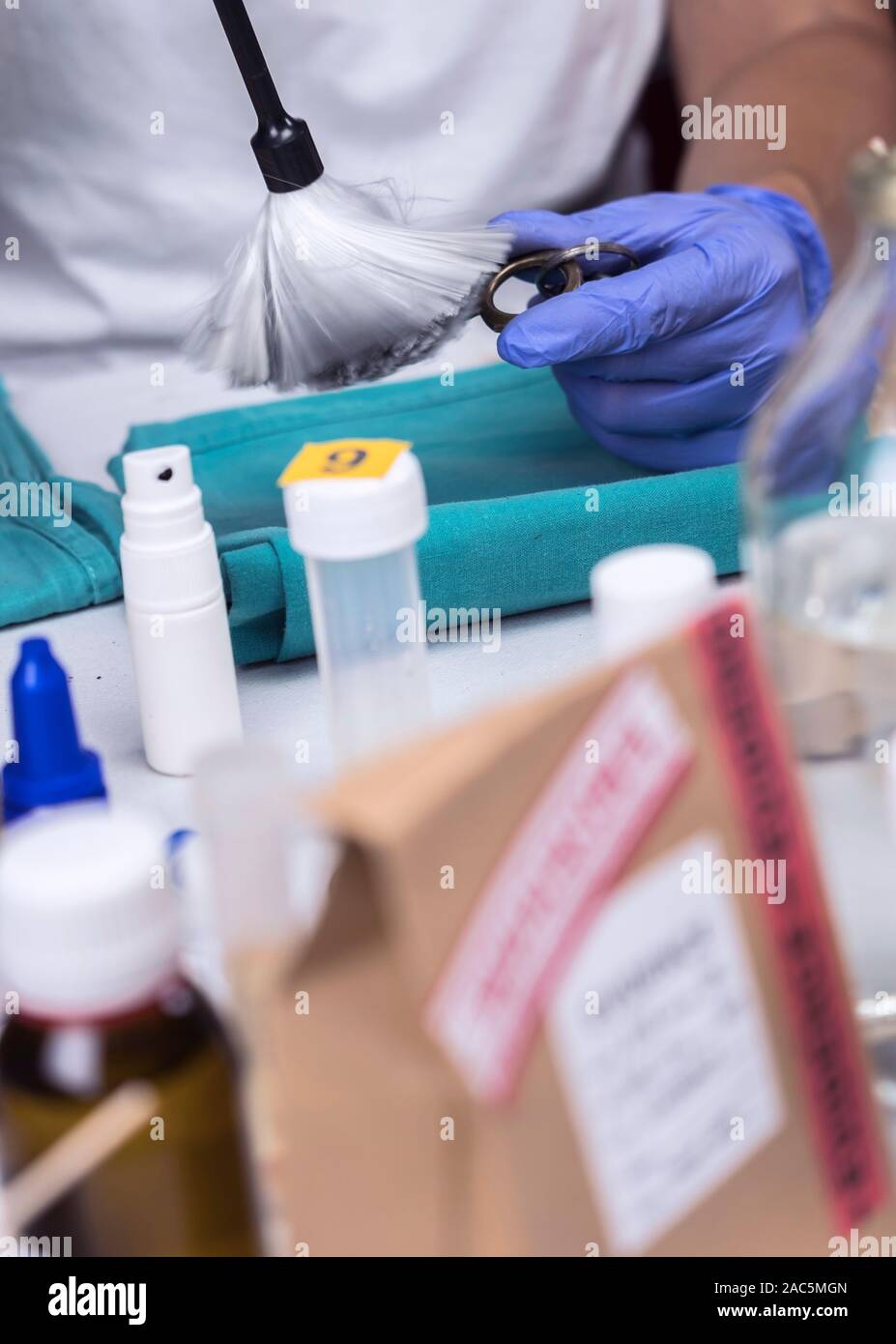 Polizia scientifica officer esamina le chiavi del test di scena del crimine, immagine concettuale Foto Stock