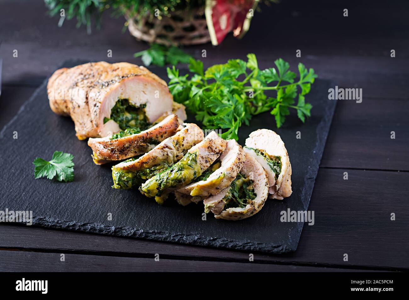 Arrosto di Natale a fette il rotolo di tacchino con spinaci e formaggio rustico scuro dello sfondo. Festival del cibo. Foto Stock