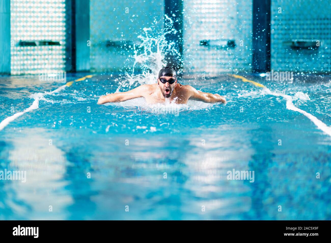 Professional nuotatore ginnastica in piscina interna. Foto Stock