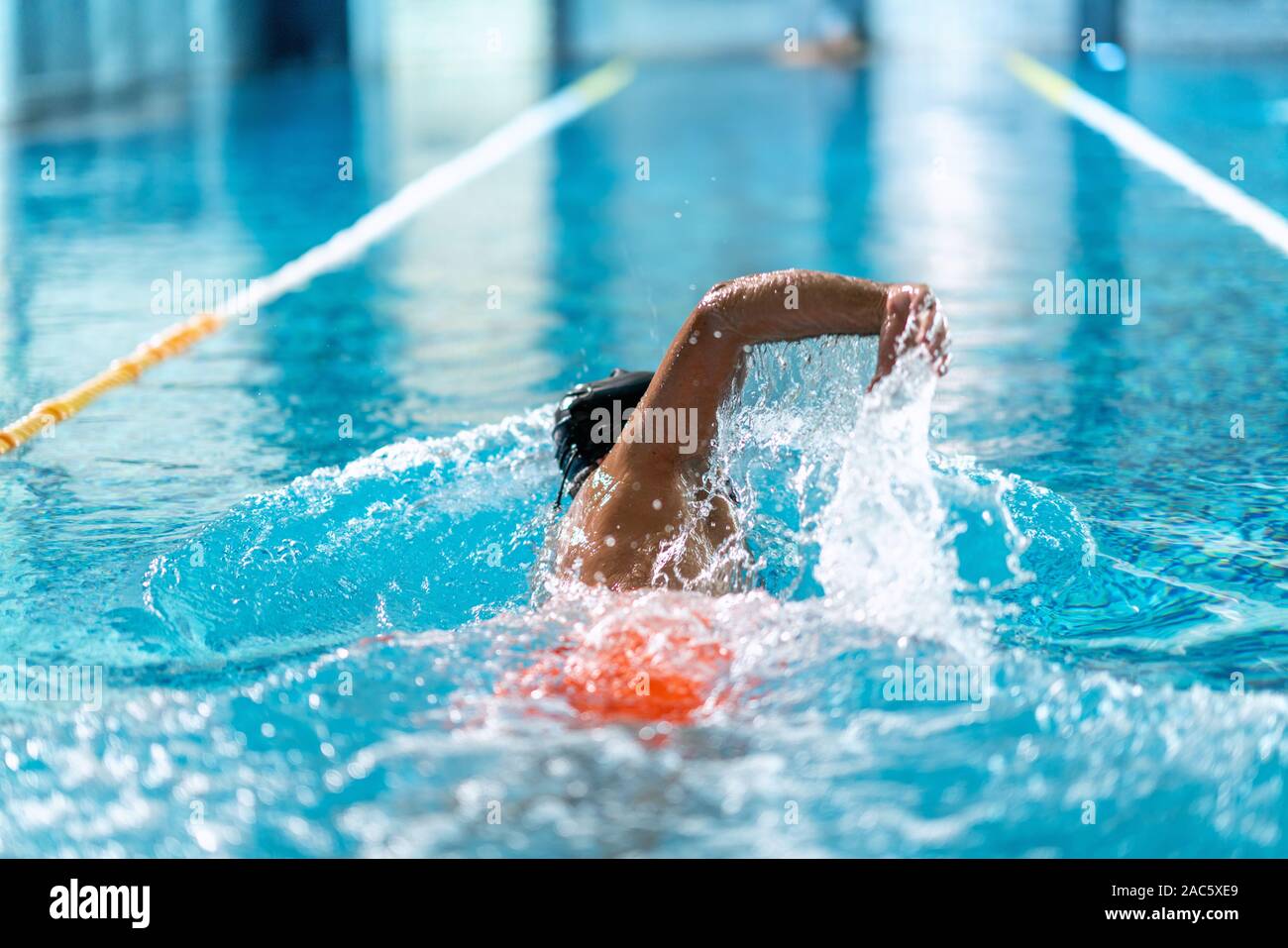 Professional nuotatore ginnastica in piscina interna. Foto Stock