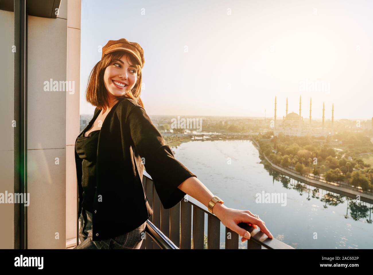 Donna che guarda la città e il fiume vista dal balcone Foto Stock