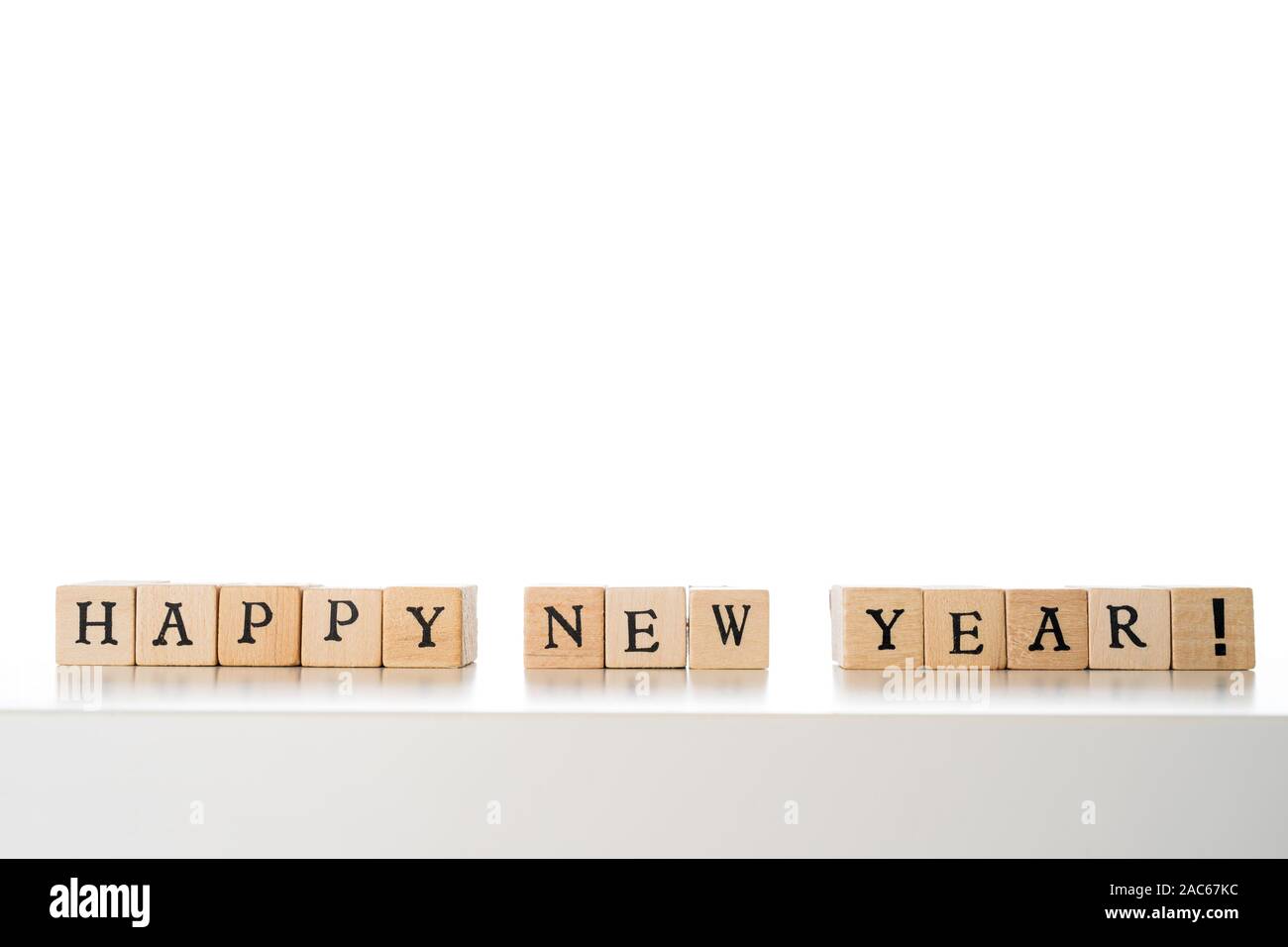 Felice Anno Nuovo testo realizzate in blocchi di legno. Isolato su sfondo bianco. Copia spazio sulla parte superiore. Foto Stock