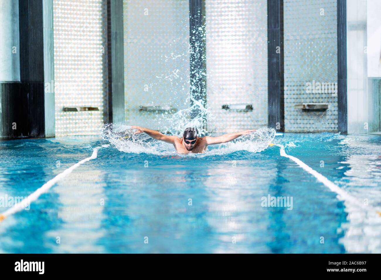 Professional nuotatore ginnastica in piscina interna. Foto Stock
