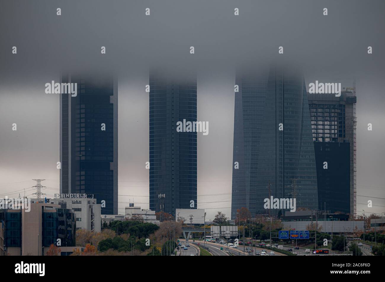 Madrid, Spagna-11.29, 2019: Le quattro torri del quartiere finanziario di Madrid tra la nebbia e l'autostrada A1. Foto Stock