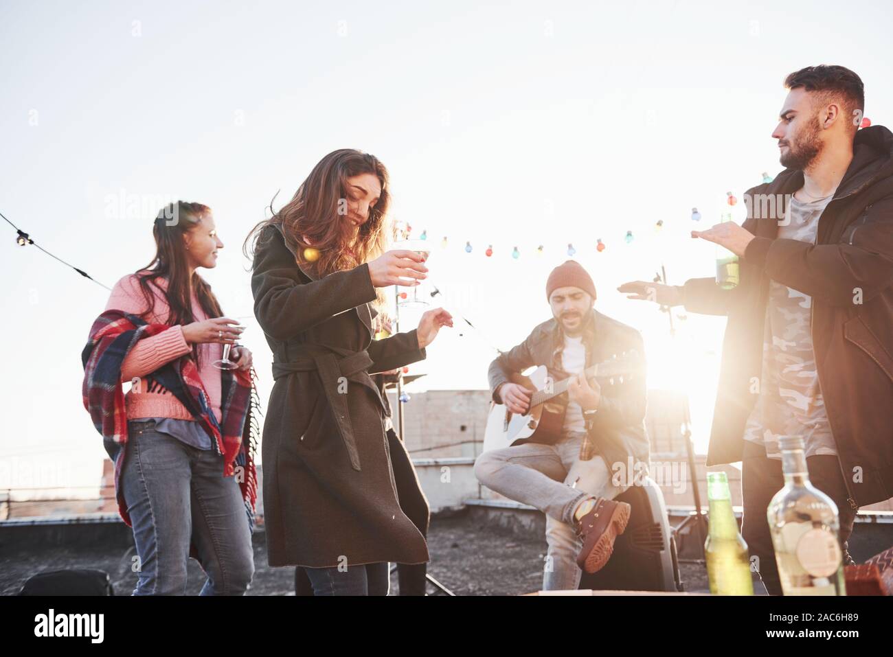 Grande sole. Tetto a qualche festa con consumo di alcool e di suonare la chitarra. Sunshine dietro Foto Stock