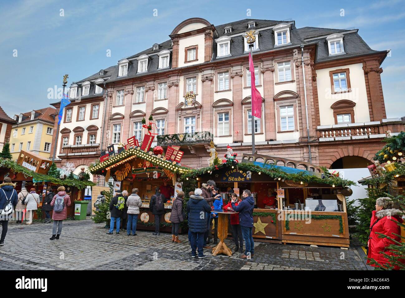 Lo stand di vendita la vendita di cibo di strada durante il tradizionale mercatino di Natale di Heidelberg city center nella parte anteriore del bellissimo municipio storico Foto Stock