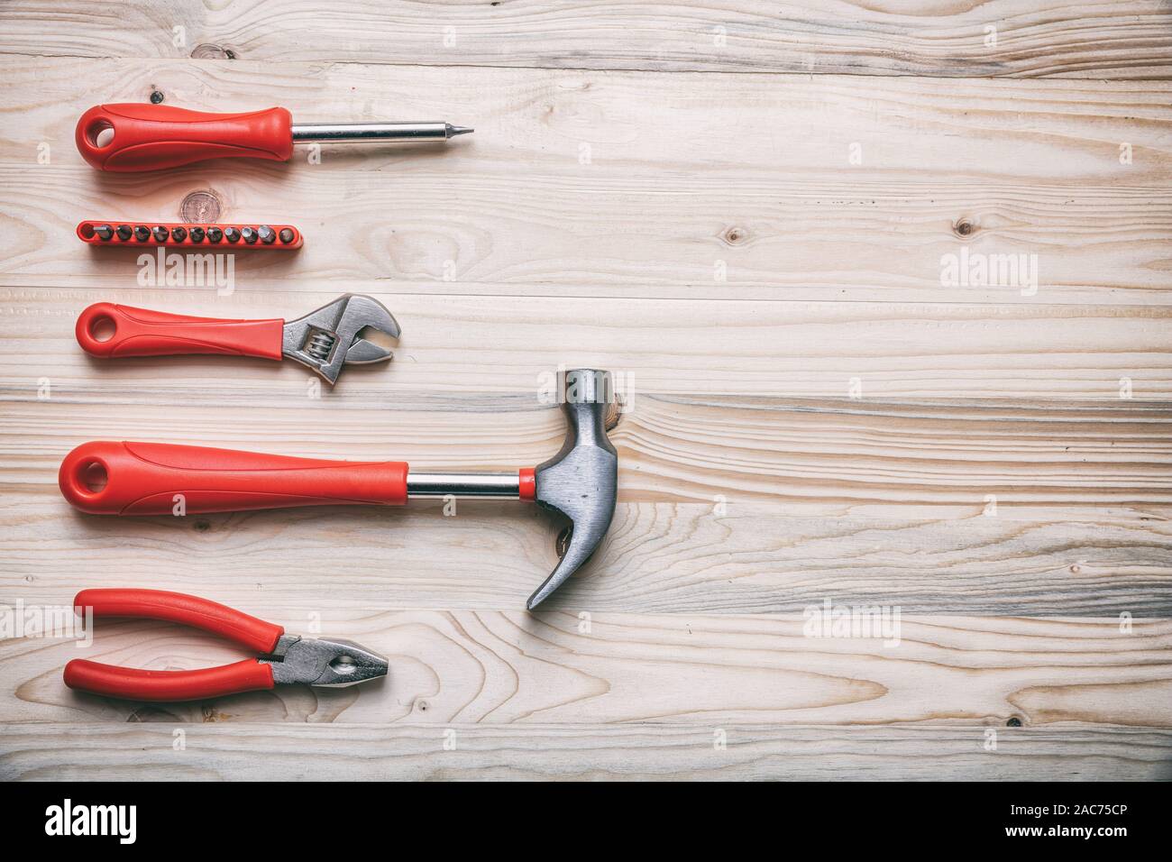 Gli strumenti a mano impostare colore rosso su legno, copia spazio, vista dall'alto. DIY, riparazione, concetto di manutenzione Foto Stock