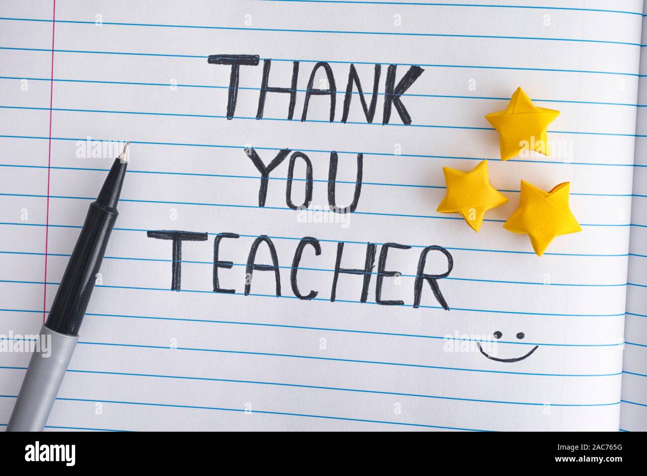 Ringrazio insegnante. Carta rigata notepad con origami stelle e parole Grazie insegnante. Close up. Foto Stock