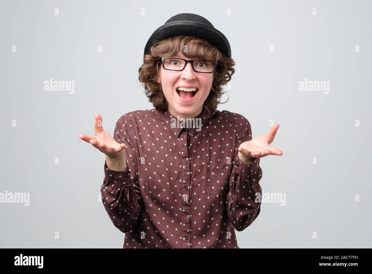 Funny caucasica donna in bicchieri e hat essendo eccitato con news Studio shot Foto Stock