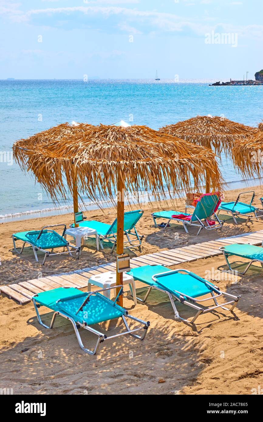Spiaggia con ombrelloni di paglia dal mare sulla soleggiata giornata estiva Foto Stock