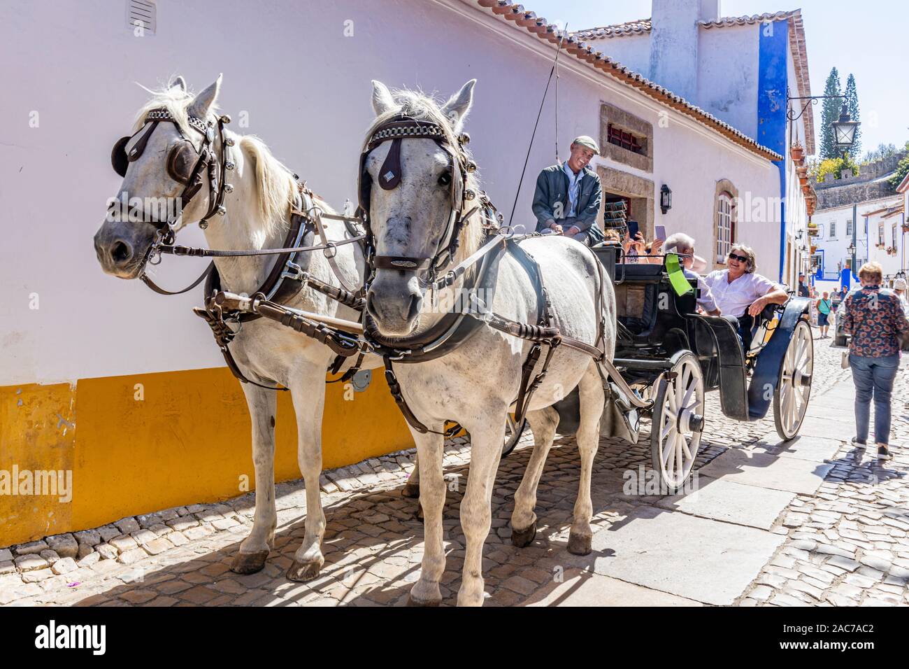 Obidos, Portogallo. Originariamente un twn fortificata ma ora una popolare destinazione turistica. I turisti a fare un giro su un carro trainato da cavalli Foto Stock