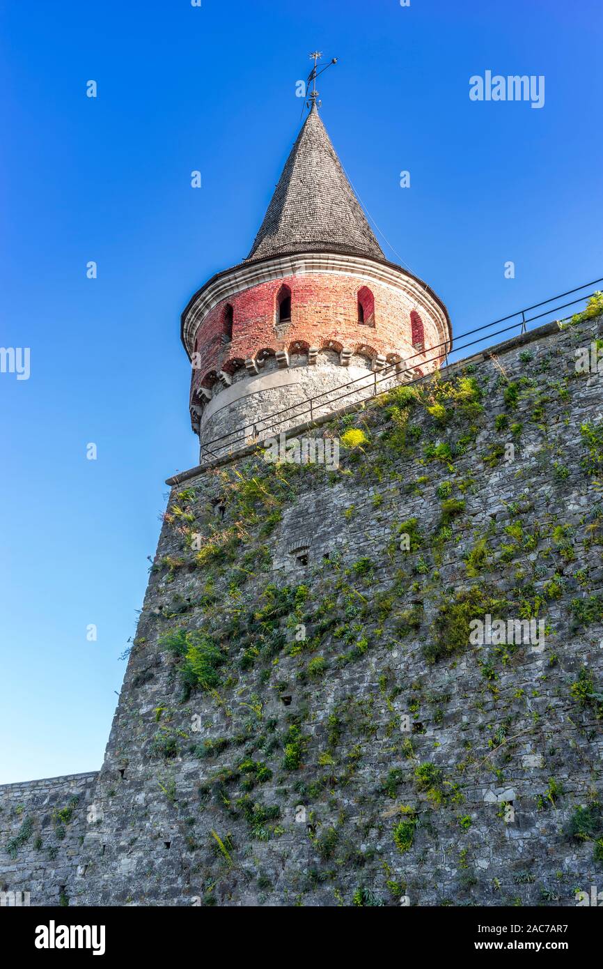 Torre in pietra di un vecchio castello con una muraglia difensiva gemellate con piante, Kamenetz-Podolsk, Ucraina, Europa, Sep.2019 Foto Stock