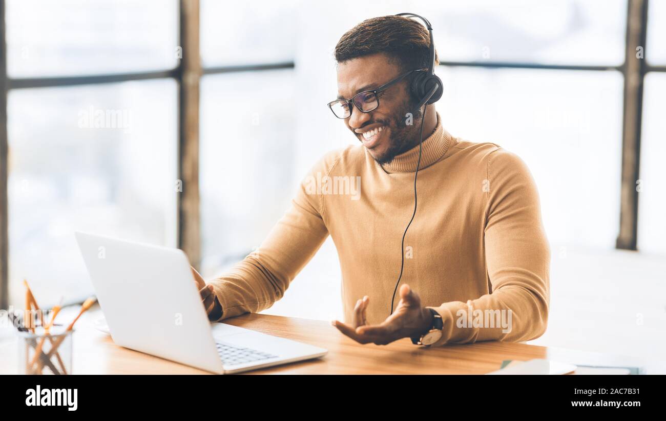 Felice receptionist nero lavorando in call center Foto Stock
