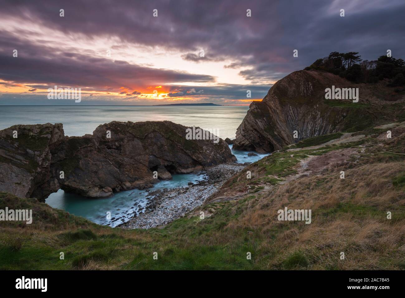 Lulworth, Dorset, Regno Unito. 1 dicembre, 2019. Regno Unito Meteo. Edificio di nuvole nel cielo di tramonto al foro di scale a Lulworth nel Dorset alla fine di una fredda giornata di sole il primo giorno d'inverno. Credito Foto: Graham Hunt/Alamy Live News Foto Stock