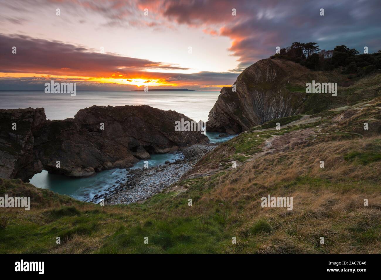 Lulworth, Dorset, Regno Unito. 1 dicembre, 2019. Regno Unito Meteo. Edificio di nuvole nel cielo di tramonto al foro di scale a Lulworth nel Dorset alla fine di una fredda giornata di sole il primo giorno d'inverno. Credito Foto: Graham Hunt/Alamy Live News Foto Stock
