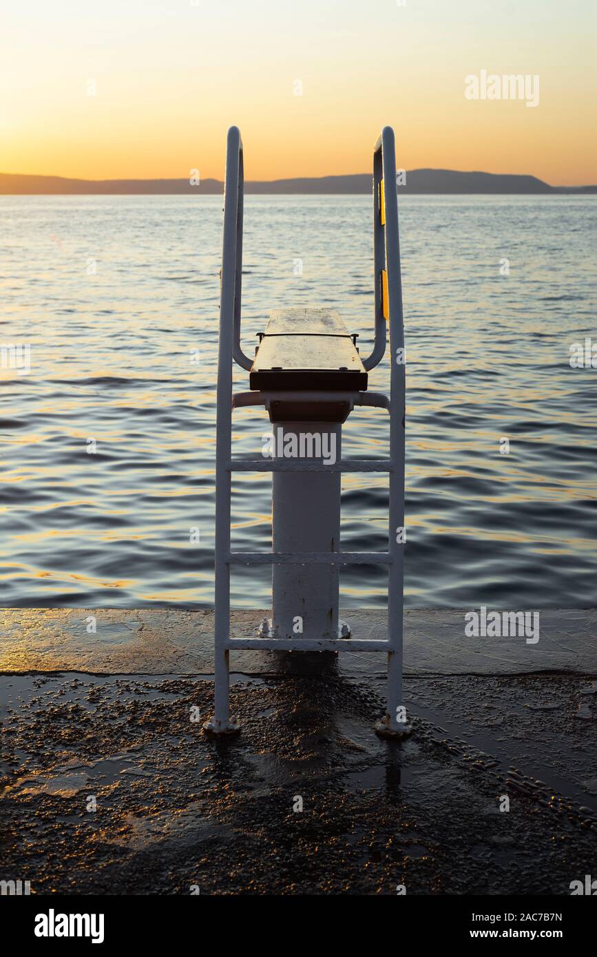 Vacante piattaforma subacquea con trampolino da mare sull'isola di Cherso nel Golfo del Quarnero illuminato golden al tramonto, Croazia Foto Stock