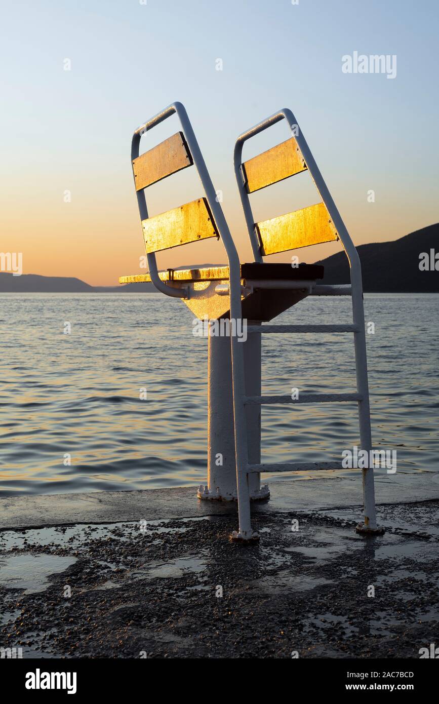 Vacante piattaforma subacquea con trampolino da mare sull'isola di Cherso nel Golfo del Quarnero illuminato golden al tramonto, Croazia Foto Stock