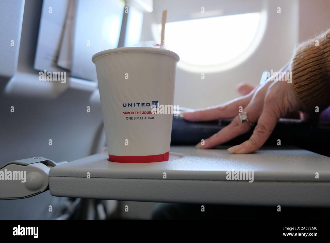 United Airlines tazza da caffè con logo e assaporare il viaggio un Sip in un momento tag line su un aereo vassoio tabella. Foto Stock