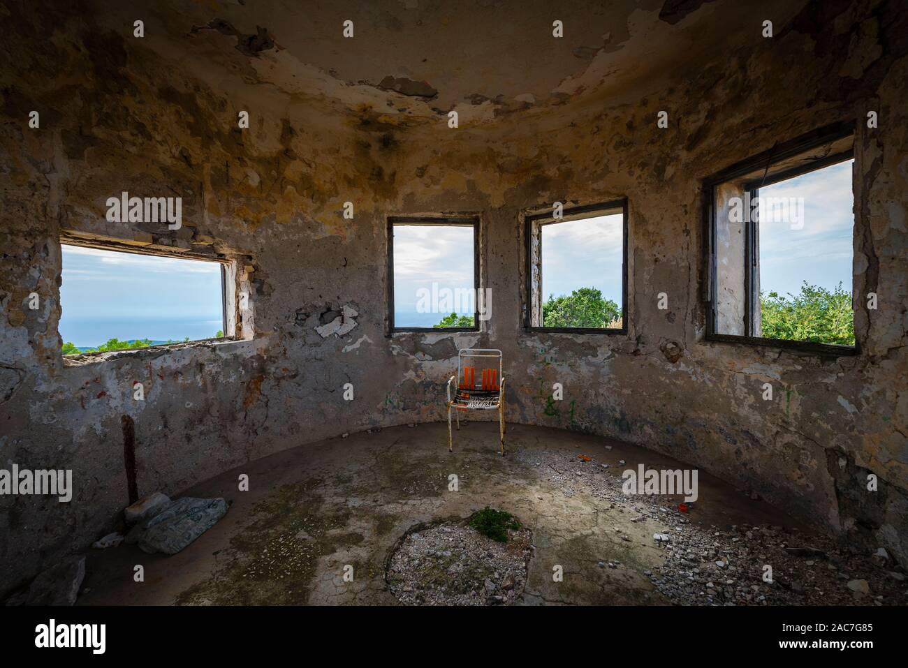 Sedia rotta nella parte anteriore della finestra delle rovine di un palazzo del XIX secolo sulla fortezza il ronzio montagna vicino la città di Velu Luka, isola di Korčula, Croazia Foto Stock