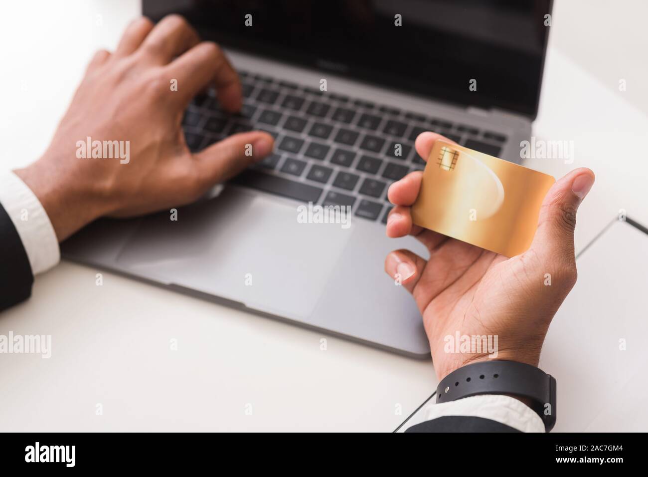 Le mani di uomo digitando il numero della carta di credito sul computer portatile Foto Stock