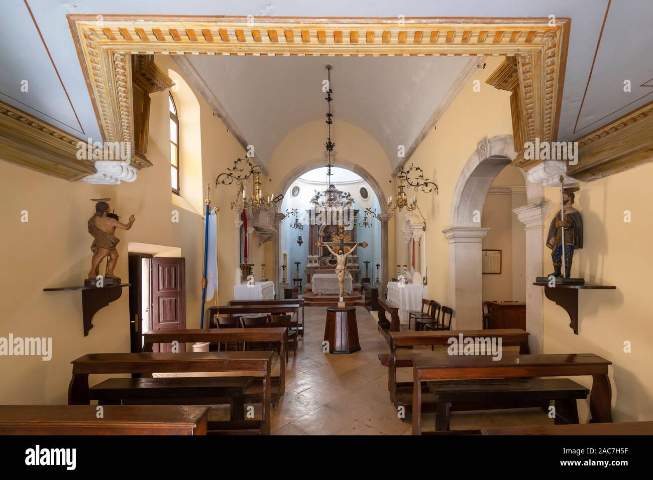 File di banchi e l'altare nella cappella di Sv. Michele nella vecchia città di Curzola, sud della Dalmazia, Croazia Foto Stock