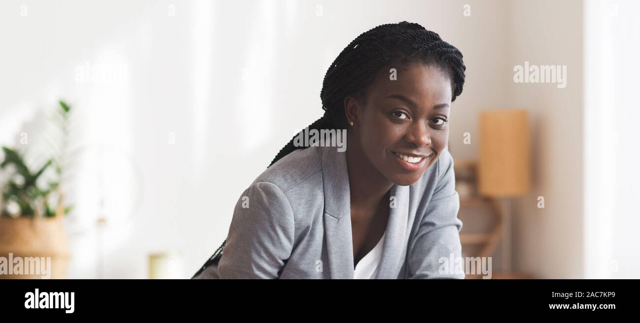 Ritratto di femmina nero dipendente si è appoggiato su qualcosa sul posto di lavoro Foto Stock