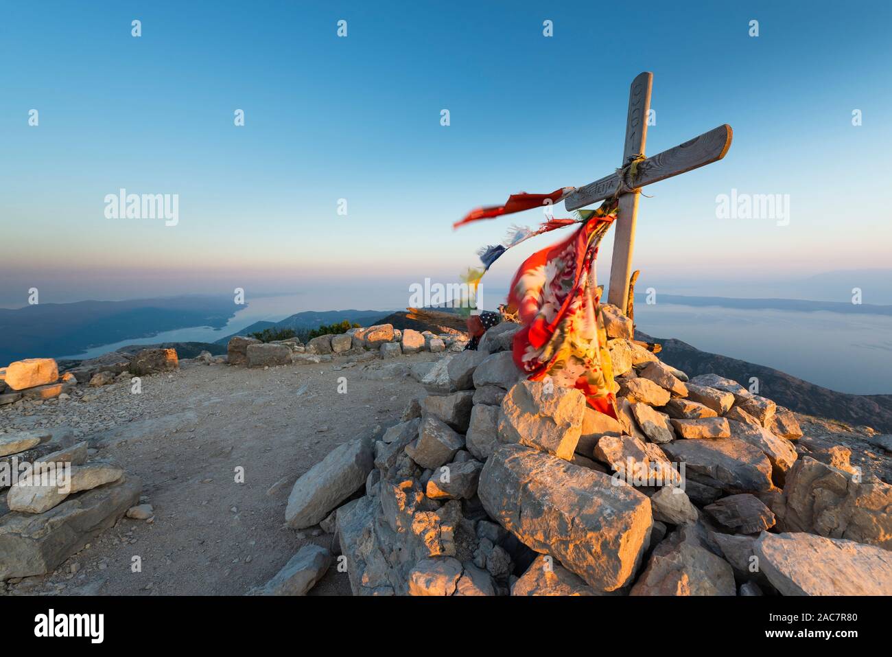 Il vertice di croce sulla cima di Sv. Ilija sulla penisola di Pelješac davanti a un panorama dell'isola di Hvar, Brac, sud della Dalmazia, Croazia Foto Stock