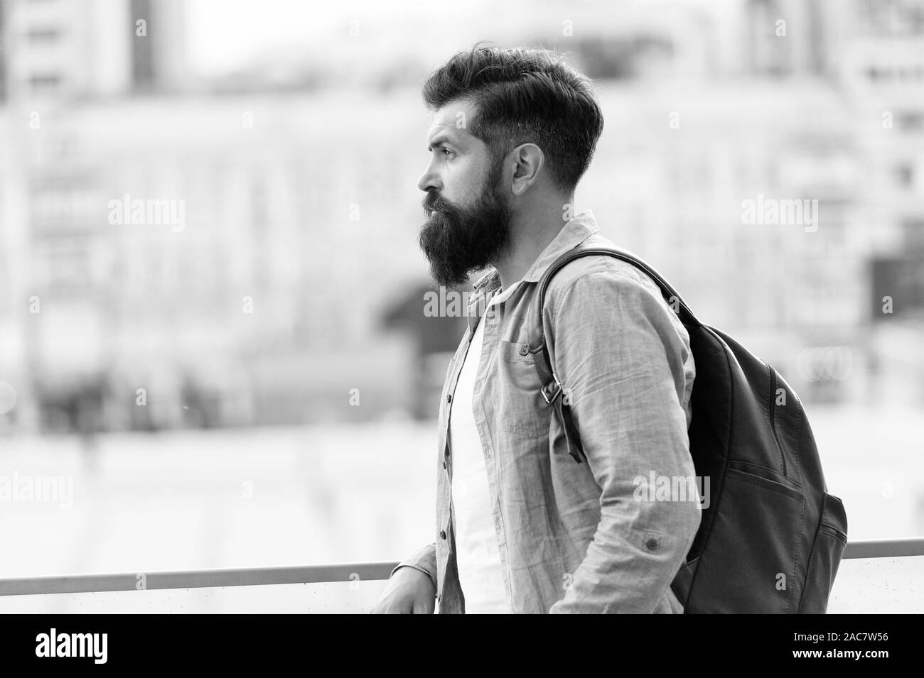 In cerca di avventure. Tourist bello pensieroso hipster zaino. Uomo con la barba e zaino esplorare la città. Il concetto di viaggio. Turisti in vacanza. Hipster turista moderno background urbano. Foto Stock